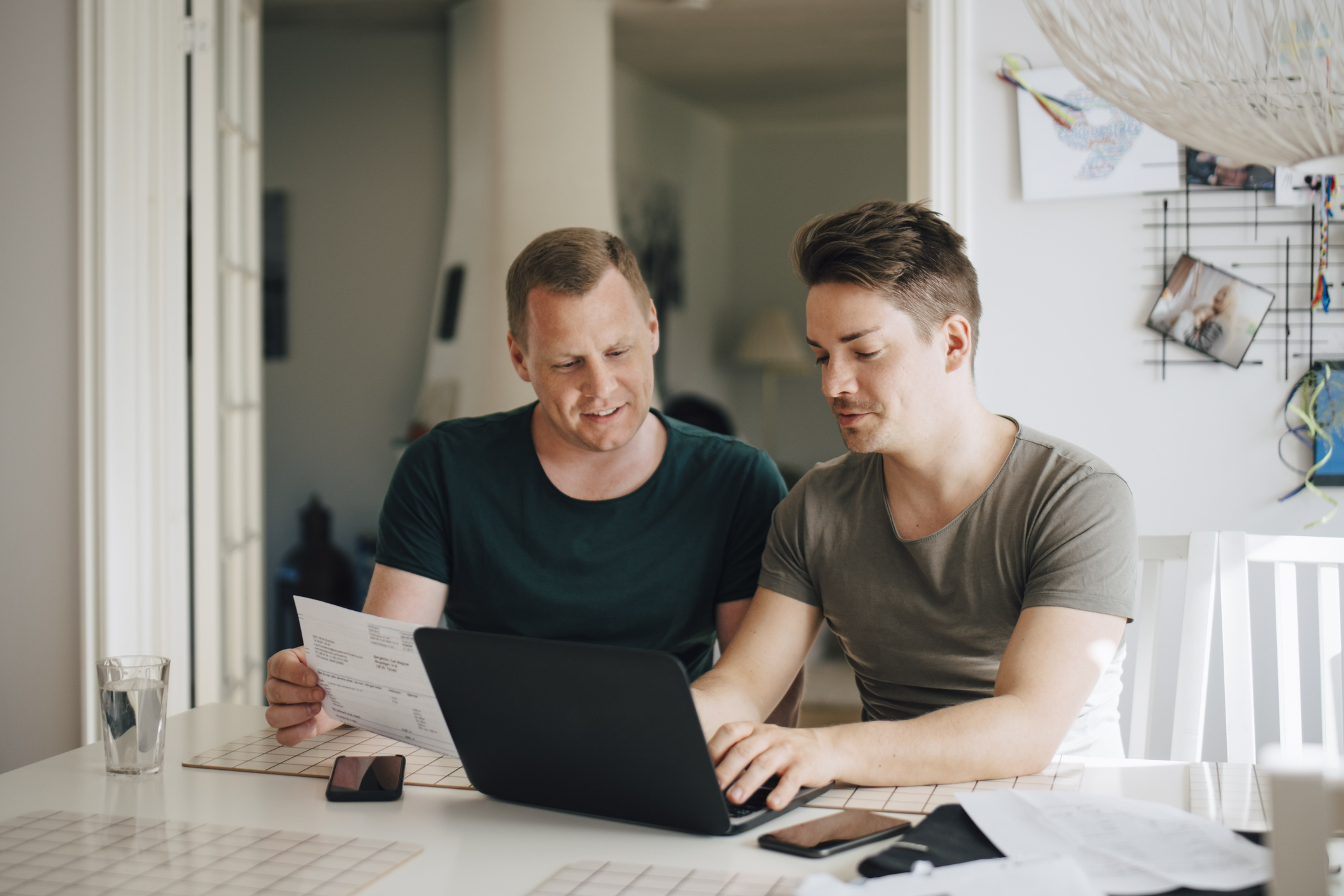 To menn sitter med pc-en og ser på en regning